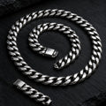 Polished stainless steel Cuban link chain necklace on black slate
